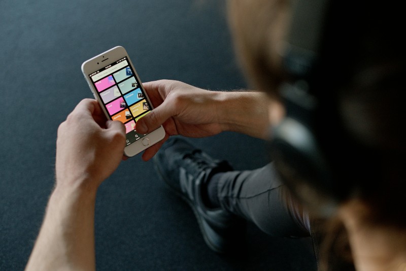 Streaming Royalty Calculator: What Your Streams Are Worth - Person using Spotify on their mobile phone